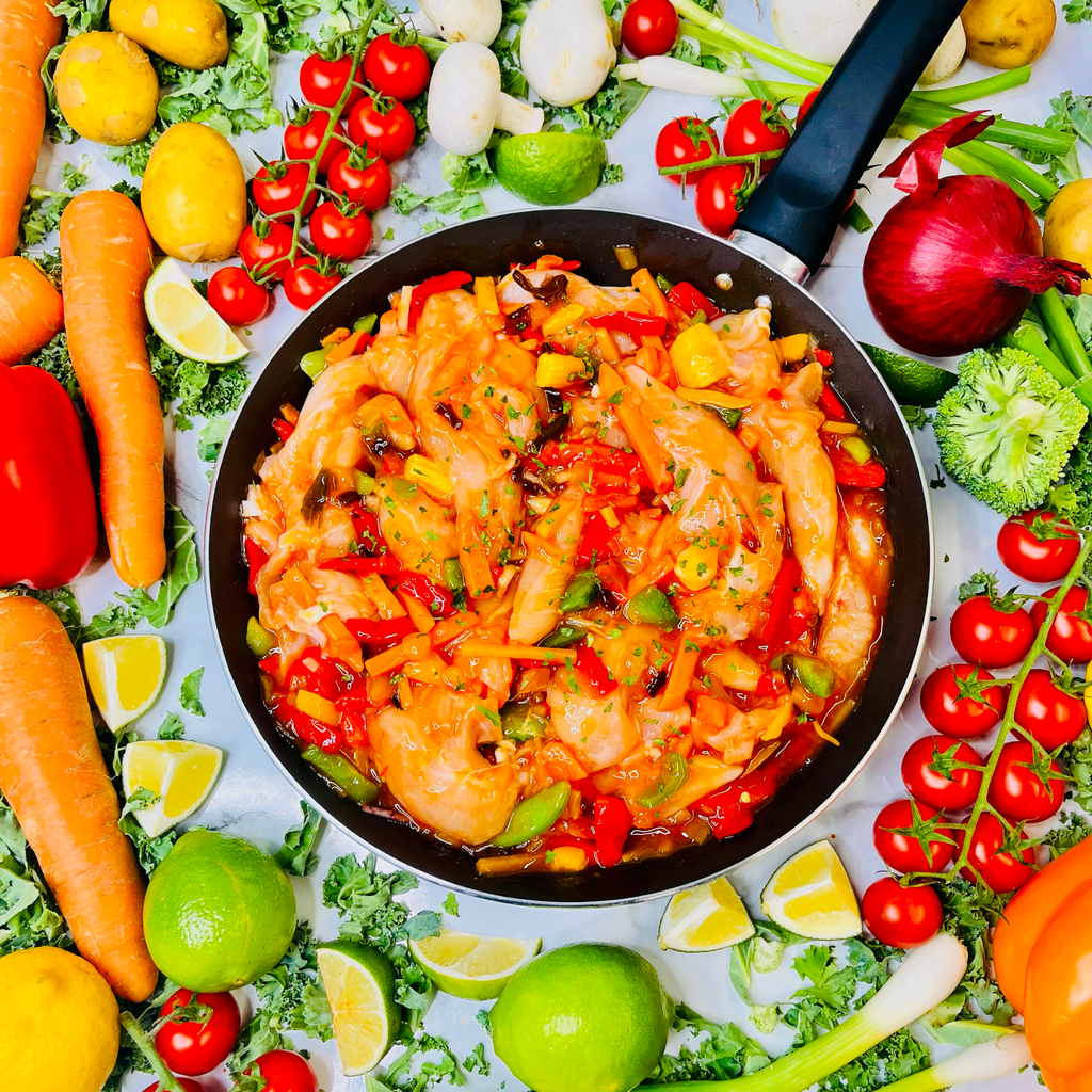 Sweet & Sour Chicken Stir Fry in a frying pan with vegetables around