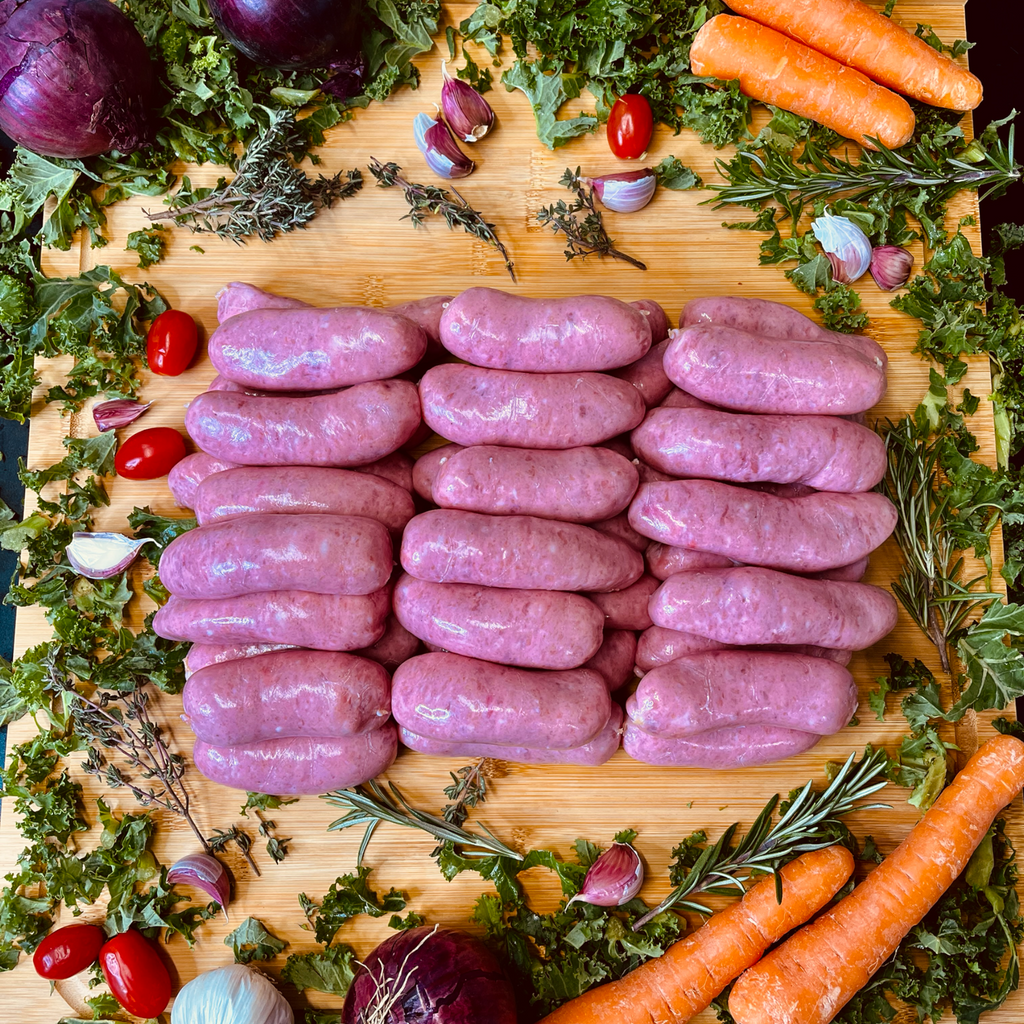 Cumberland sausages, spices and vegetables on a chopping board