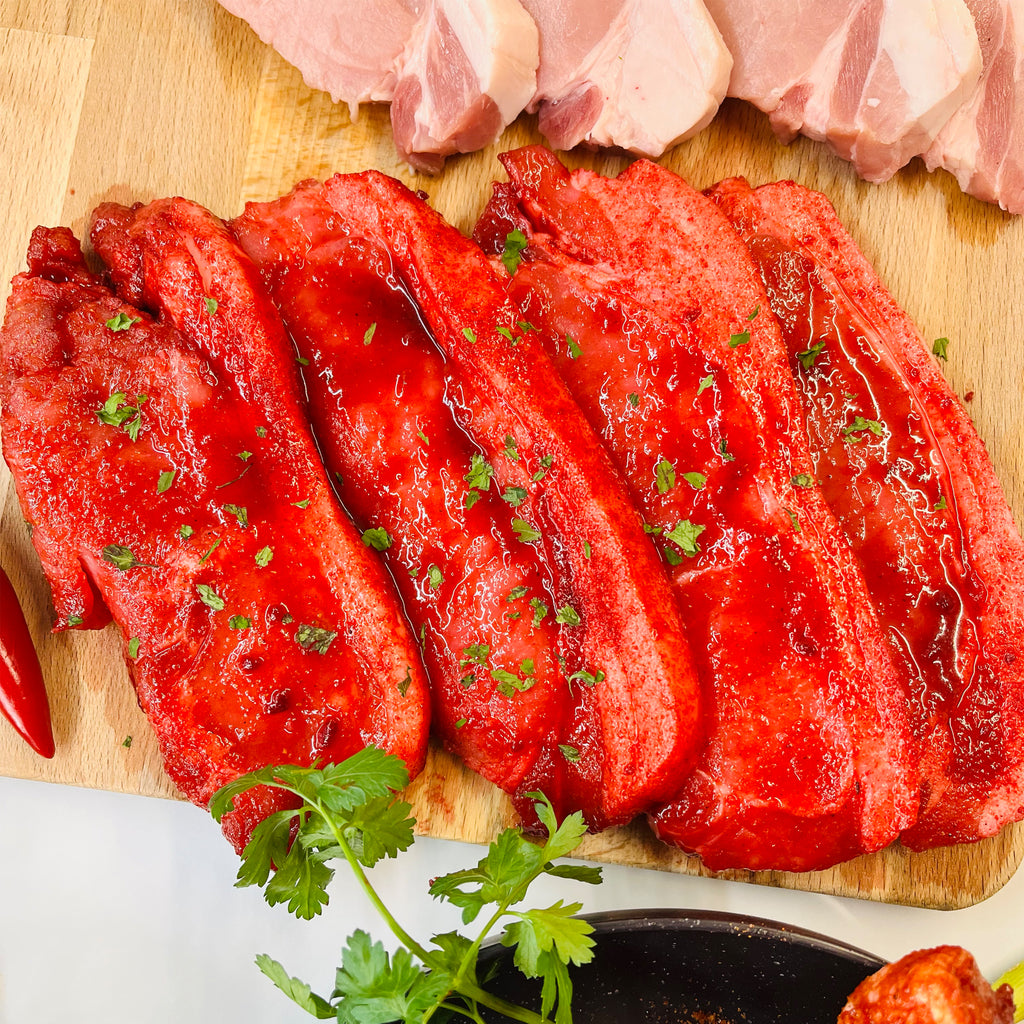 Four marinated pork loin steaks with spices
