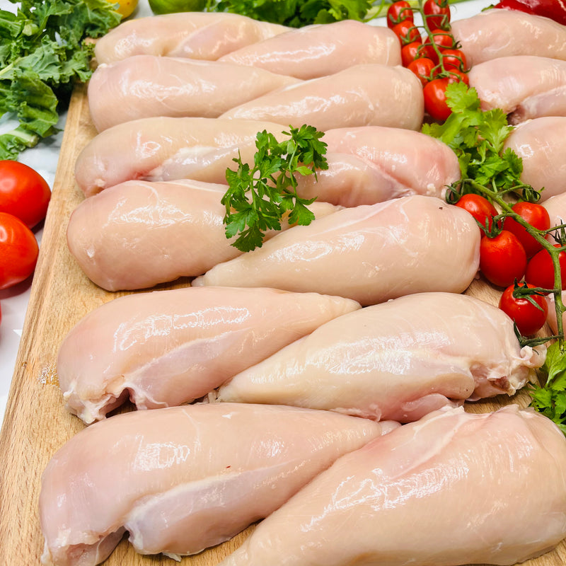 12 Chicken Breasts on a chopping board with vegetables around
